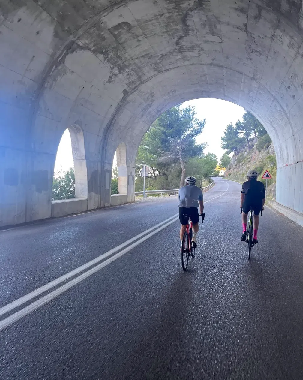 Rennradfahrer auf der MA-10-Küstenstraße auf Mallorca — beeindruckende Aussicht über Serra de Tramuntana und Mittelmeer