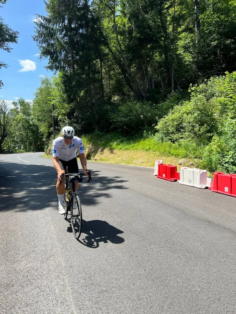 Climbing a shaded hairpin on the Glandon past roadworks barriers.