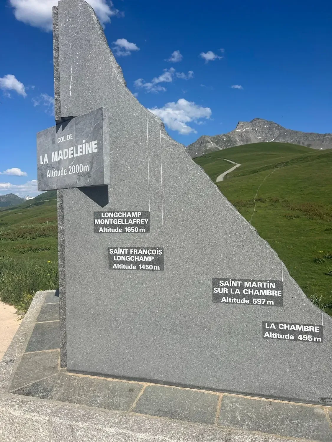 Granite summit monument listing the villages of the climb.