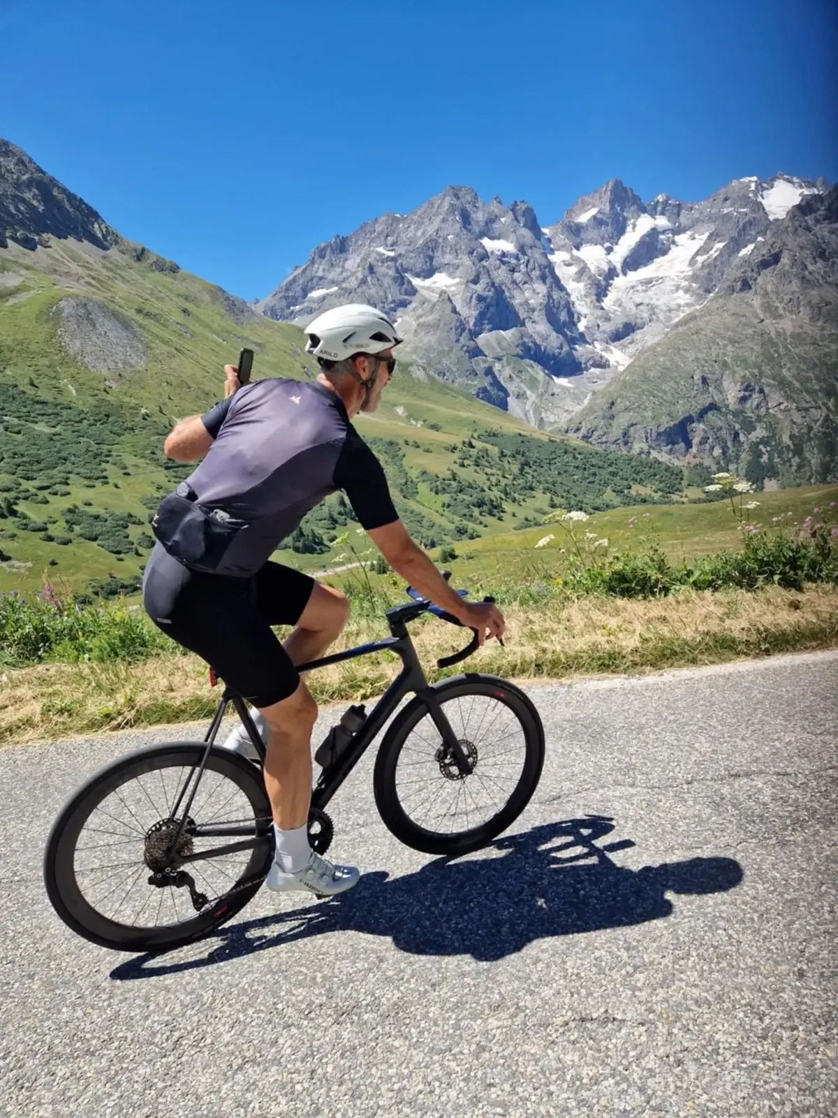 Climbing past flowering verges with La Meije and the Écrins behind