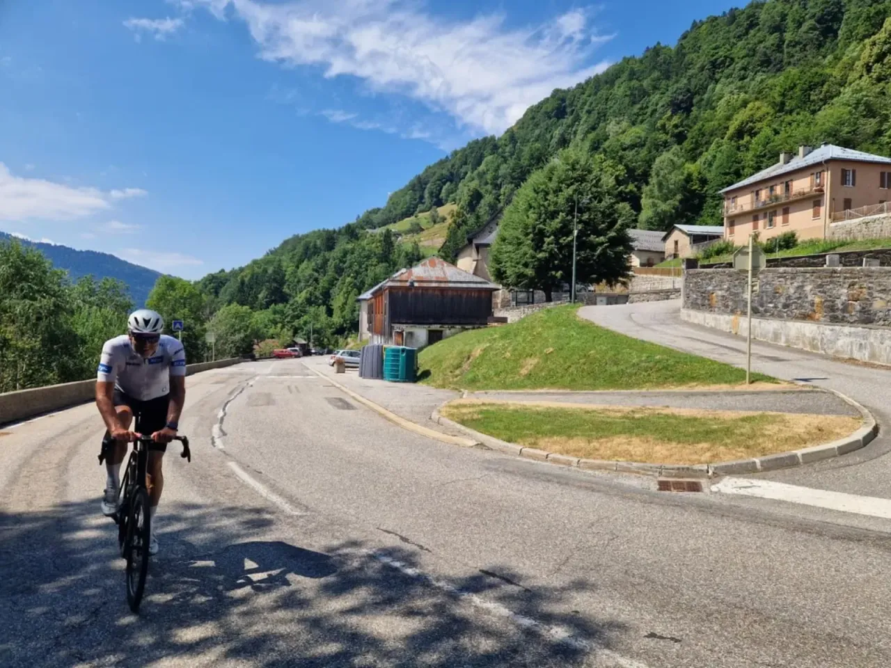 Climbing a shaded hairpin through a Savoyard village on the Côte d'Héry, Beaufortain Alps.