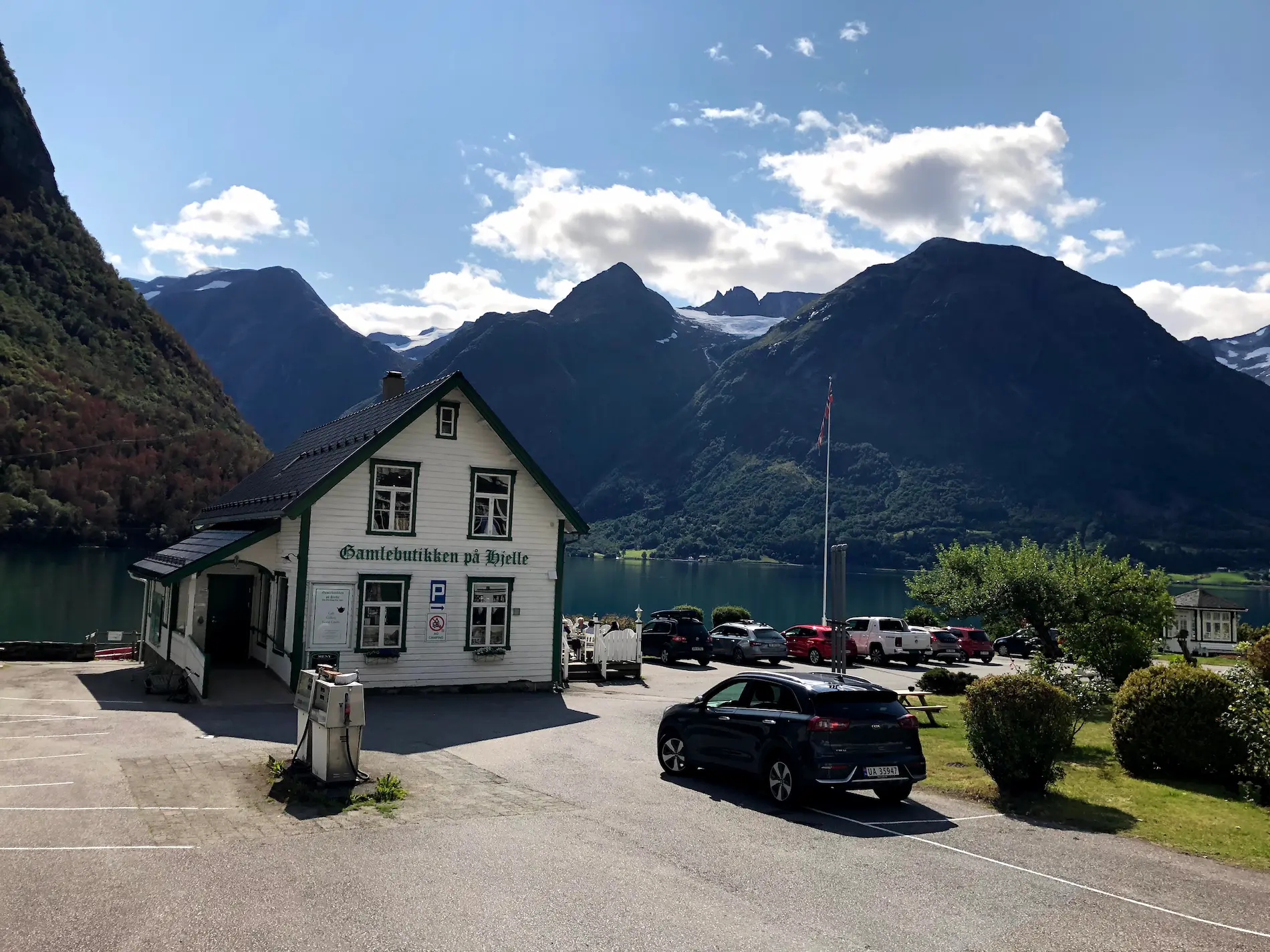 Hjelle on Oppstrynsvatnet — turkis-green glacial water and snow-capped peaks at the start of Gamle Strynefjellsveg