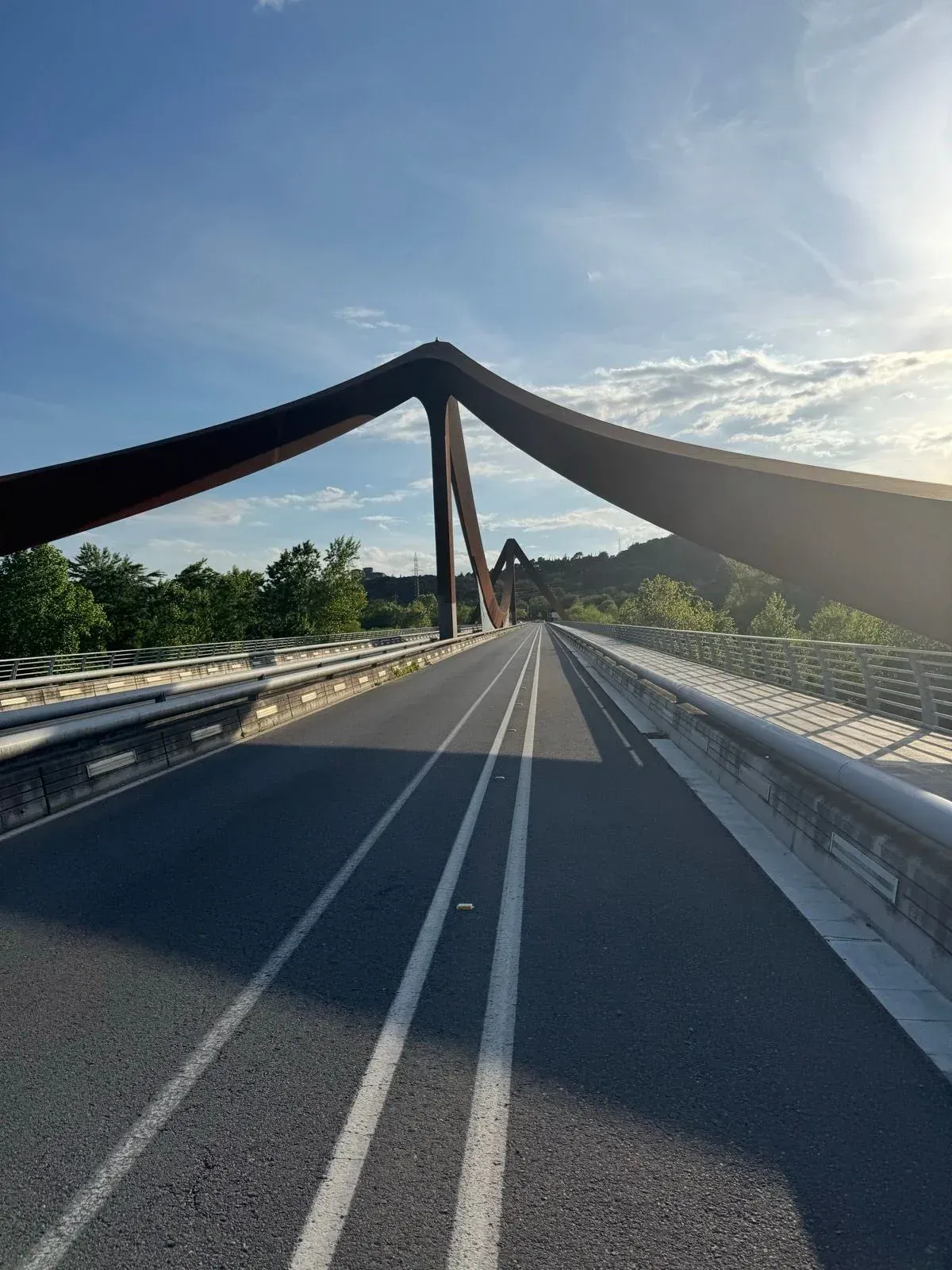 Cyclist's view over the rust-red Pont del Dimoni leaving Girona on the Banyoles loop, Catalonia.