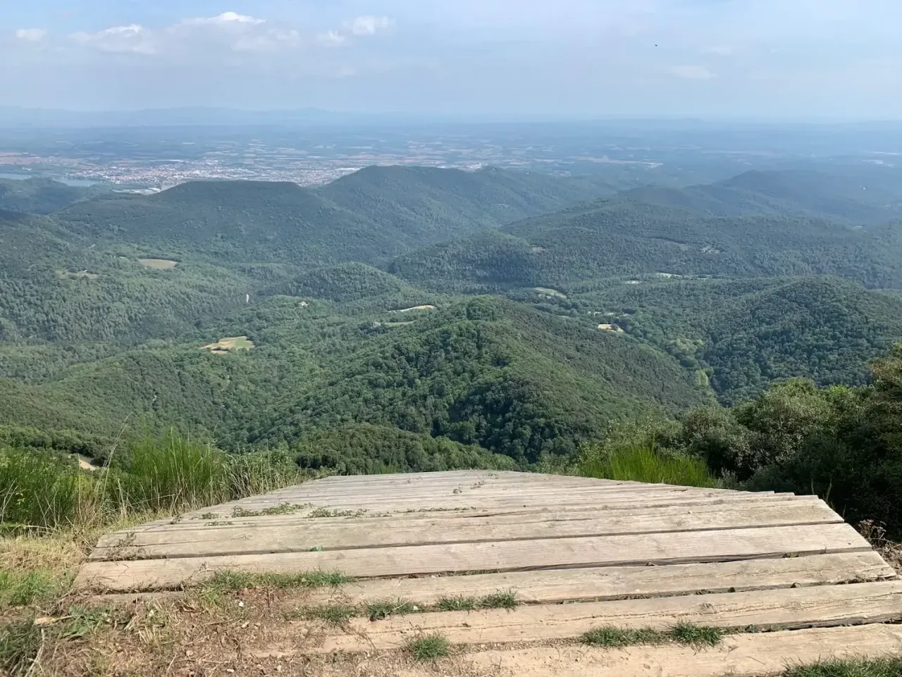 Gipfelpanorama vom Rocacorba über bewaldete Bergrücken zur Empordà-Ebene, Katalonien.