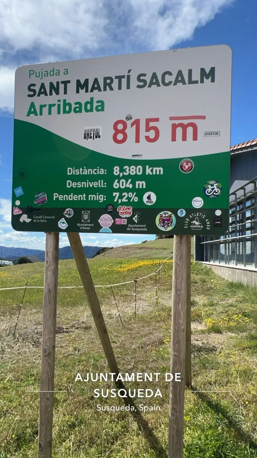 Summit sign at Sant Martí Sacalm, covered in club stickers at 815 m.