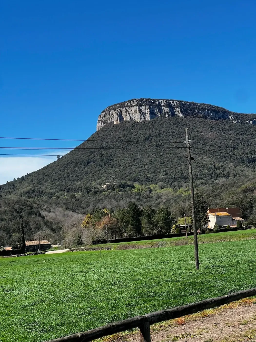 The flat-topped Guilleries cliffs rising over green spring meadows.