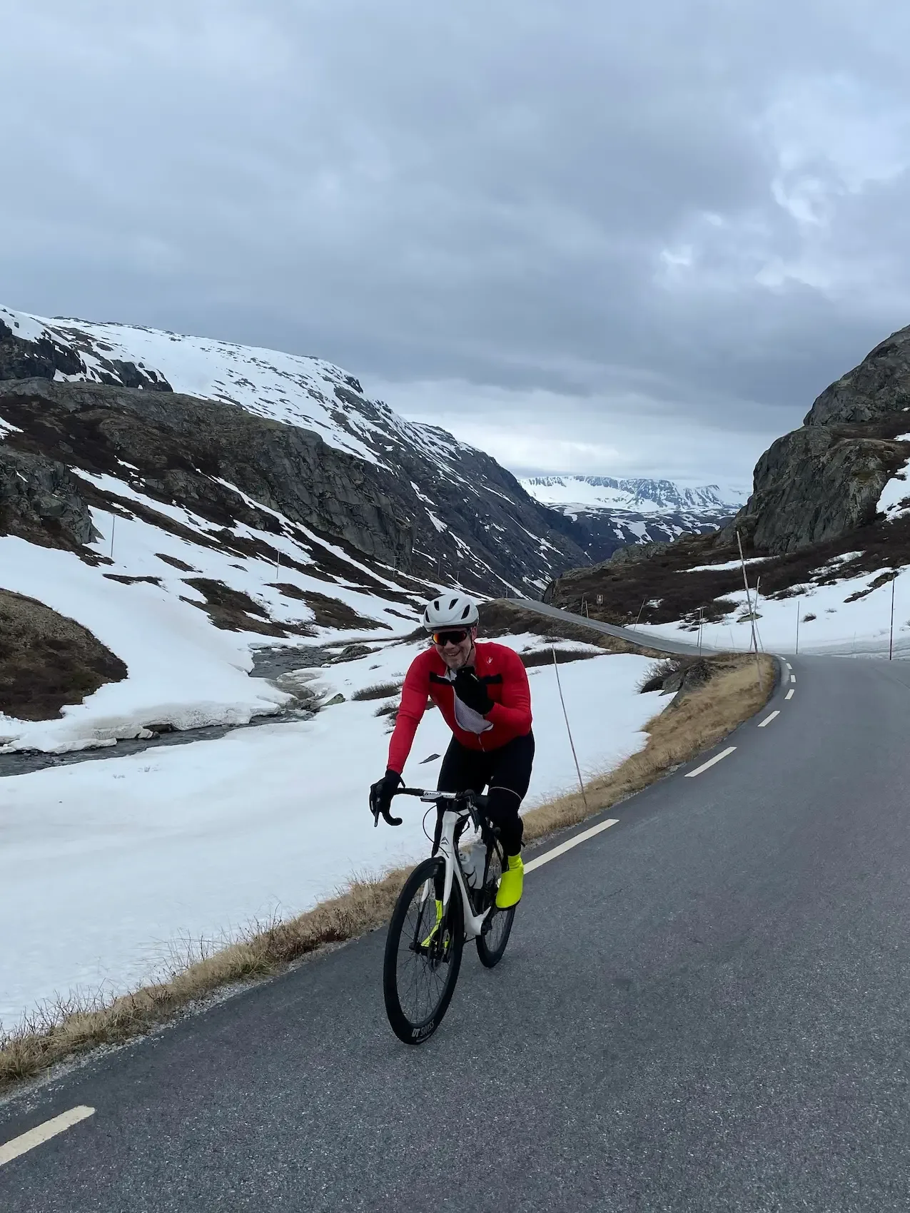 Quick pause in red and yellow socks, snowy valley behind.