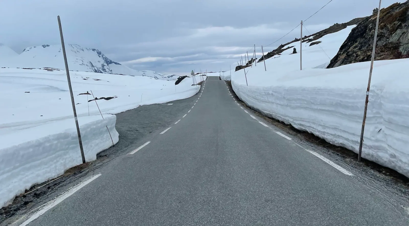 Straight tarmac between two-metre snow walls at the summit.