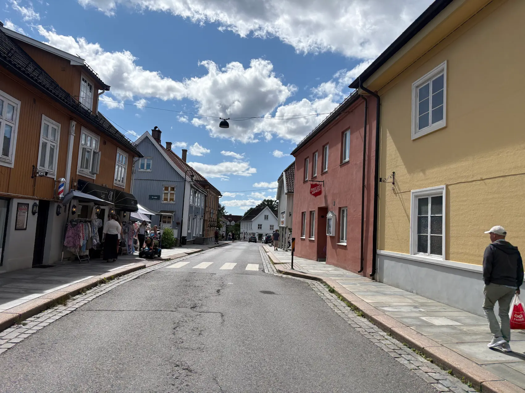 Trehusbebyggelse og butikker i Drøbak sentrum under blå himmel