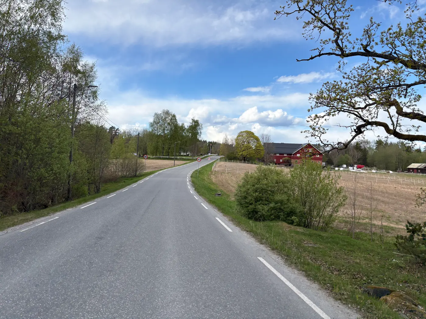 Landstraße vorbei an einem aktiven Bauernhof