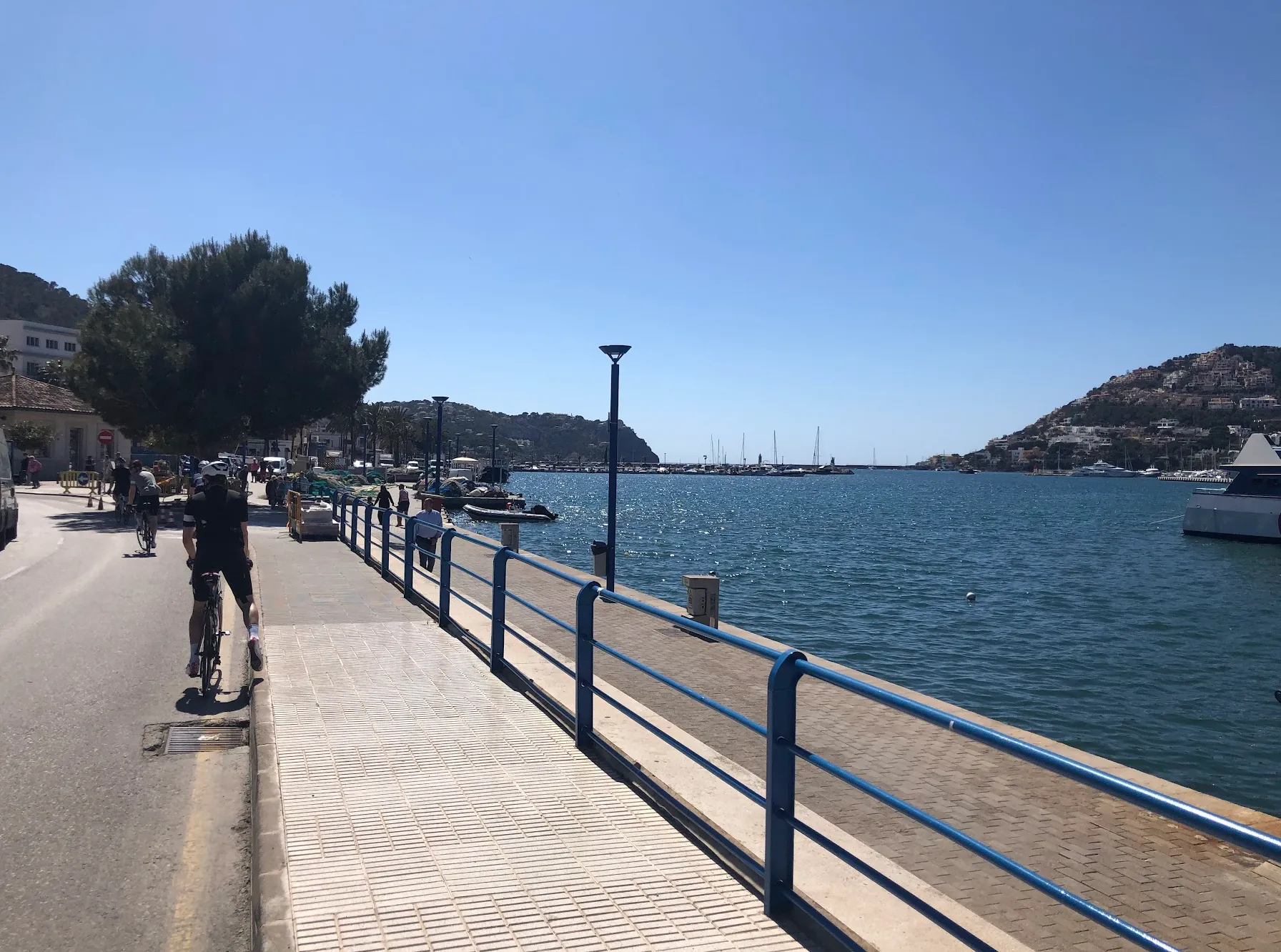 Port d'Andratx harbour, Mallorca — superyachts and waterfront cafés on a sunny cycling day