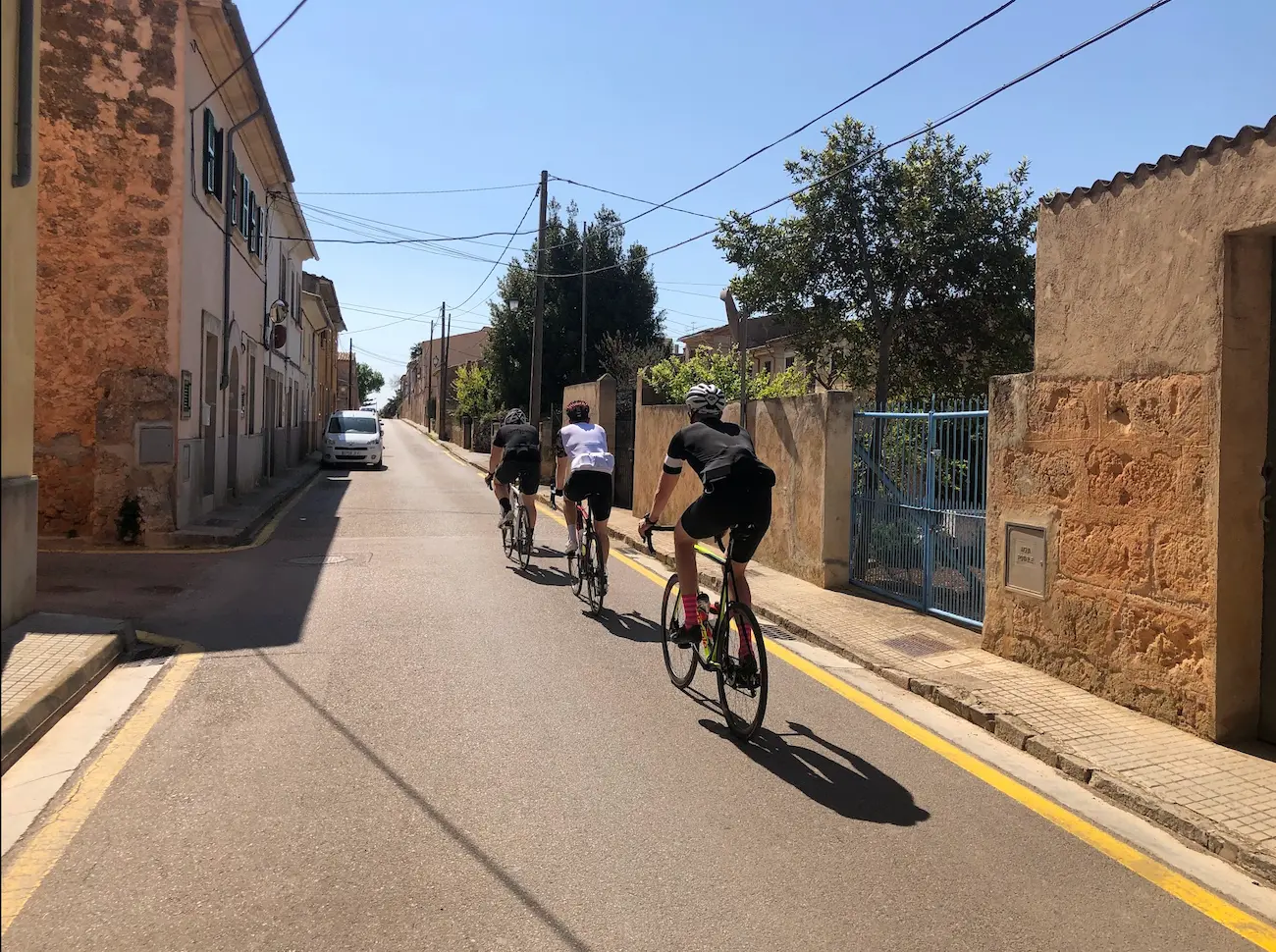 Cyclists riding through a traditional Mallorcan village on the southeast cycling route