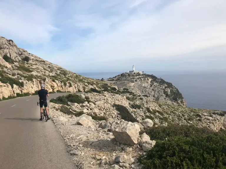 Cyclist on the Ma-2210 approaching Far de Formentor lighthouse, Cap Formentor, Mallorca.