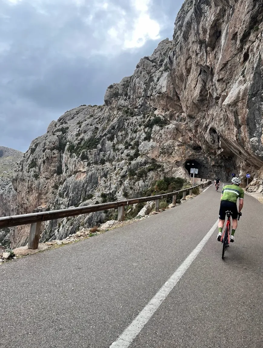 Climbing toward one of the short rock tunnels under the limestone wall.
