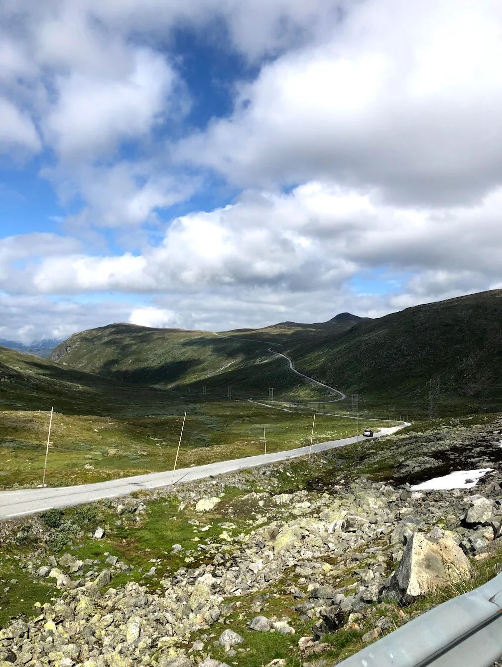 Upper Sognefjellet cycling — approaching the 1,420m summit with views across Jotunheimen national park
