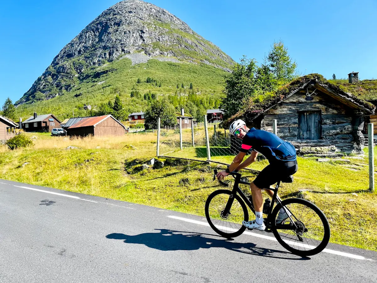 Cycling Trollstigen, Norway — the iconic Stigfossen waterfall cascading 320m beside the road
