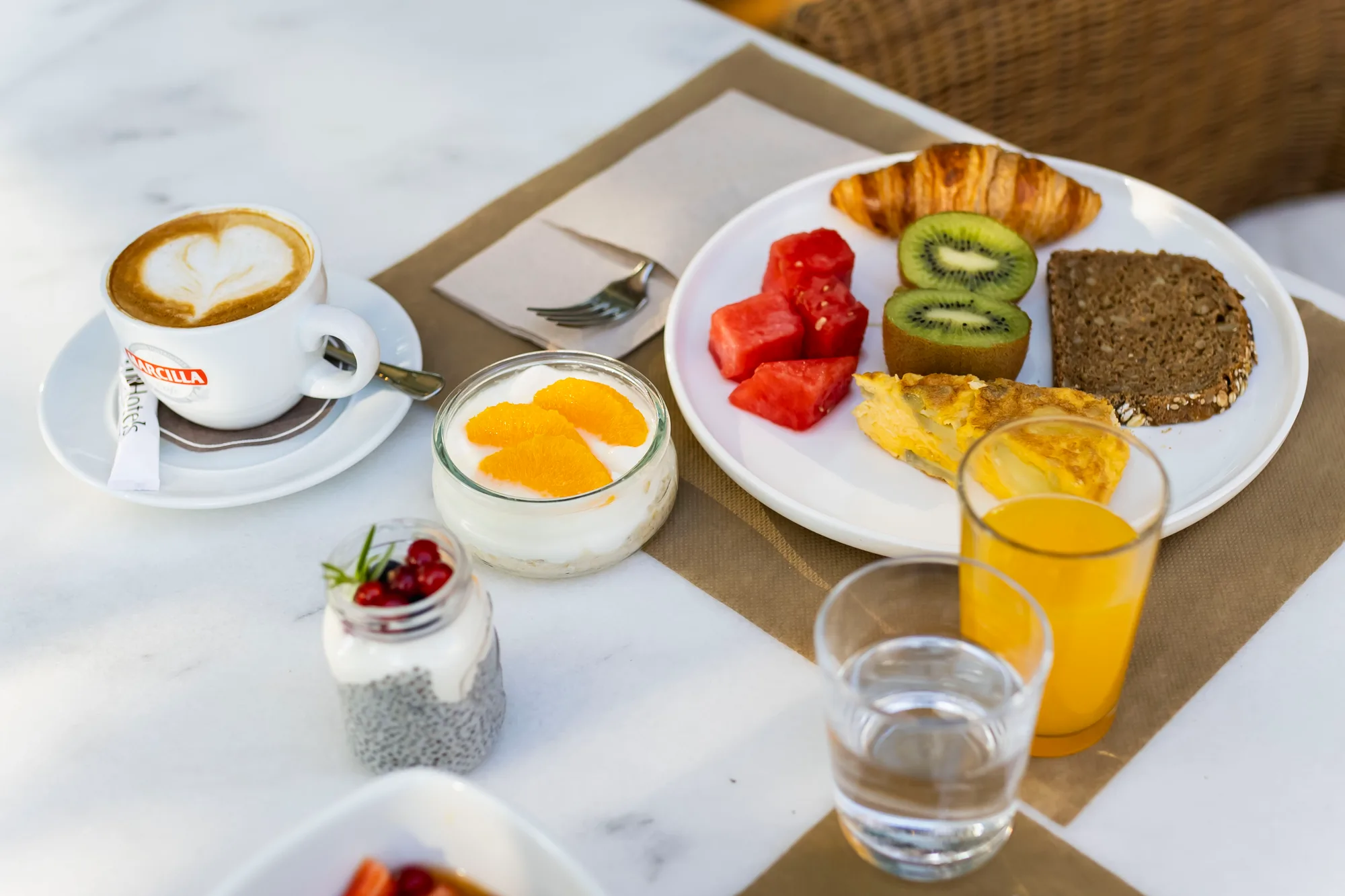 Frokost på terrassen på Hotel Les Rotes i Dénia — kaffe, frukt, tortilla og juice