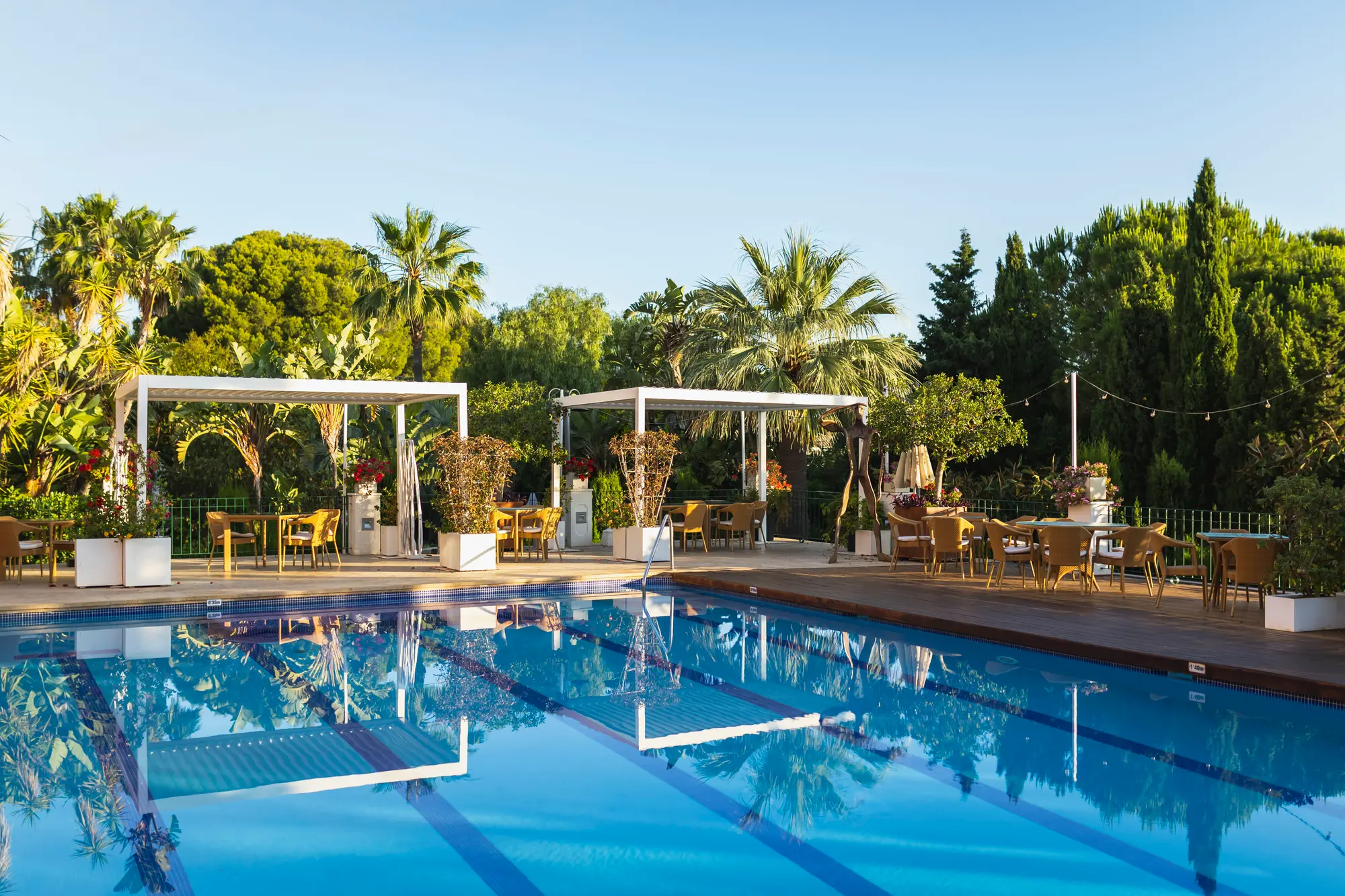 Bassenget og den frodige terrassen på Hotel Les Rotes i Dénia i kveldslys